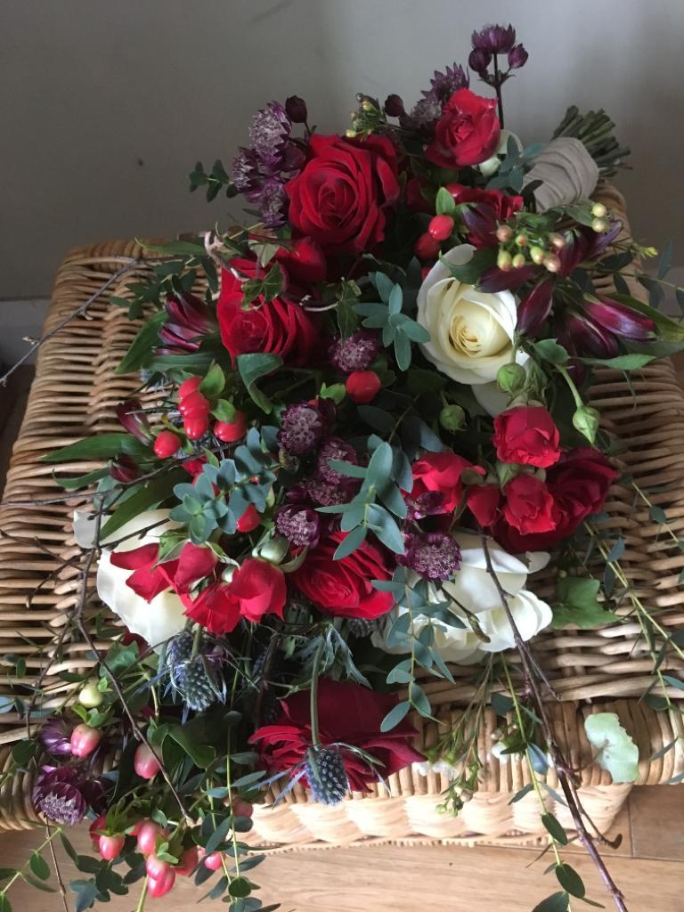 Brides waterfall bouquet, red and white roses, eucalyptus and thistles feature
